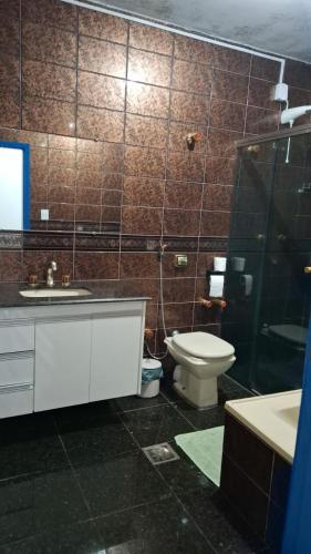 a bathroom with a toilet and a shower and a sink at SUÍTE Solar do Carmo in Mariana