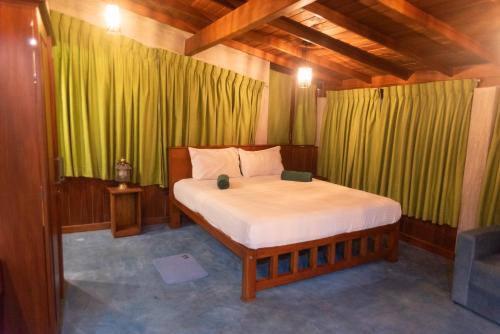 a bed in a room with green curtains at Sea Trails Bentota in Bentota