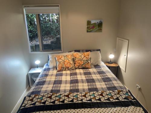 a bedroom with a bed with two lamps and a window at Close Motorway,Free Breakfast,Private & Spacious in Auckland