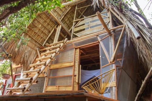 a tree house with a thatched roof at Cabaña Corazon Mazunte in Mazunte