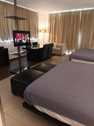 a hotel room with a bed and a flat screen tv at Playa Blanca Doble in Río Hato