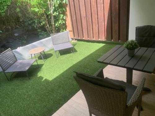 a yard with chairs and a table and grass at Tiki Ora Lodge - VARUA in Bora Bora