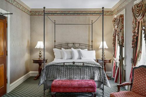 a bedroom with a bed and a red bench at Beaumont Hotel and Spa - Adults Only in Ouray