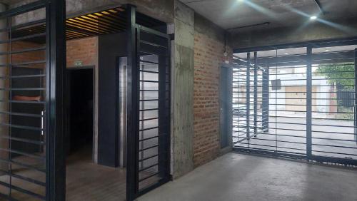 an empty room with a door and a brick wall at Malbec Studio Pilar in Pilar