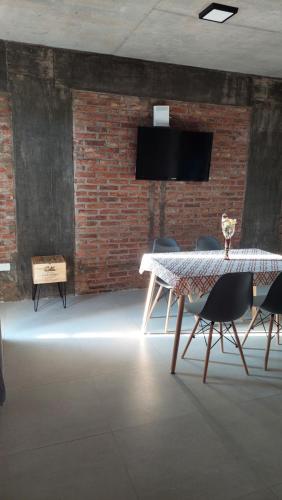 a dining room with a table and chairs and a tv at Malbec Studio Pilar in Pilar