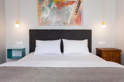 a bedroom with a large bed with white sheets at The Caravan in Thessaloniki