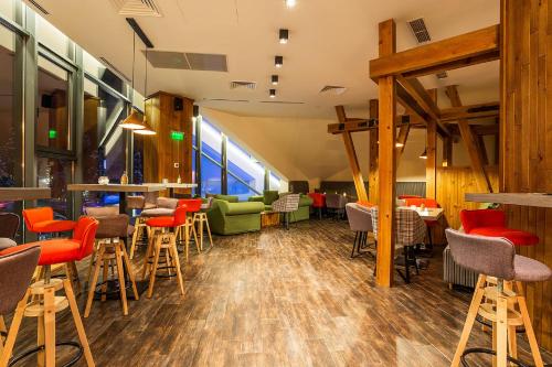 a restaurant with wooden floors and chairs and tables at Rila Hotel Borovets in Borovets