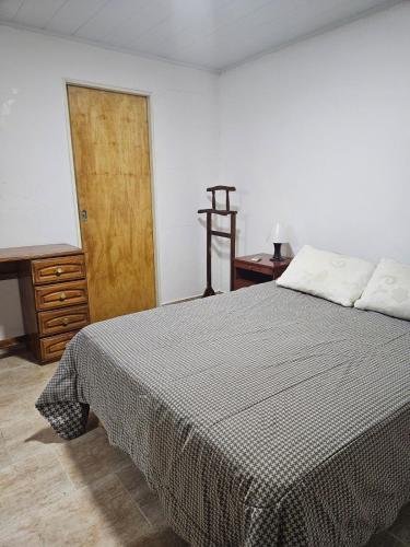 a bedroom with a bed and a wooden door at Navarro Apt 2 Ambientes in Navarro