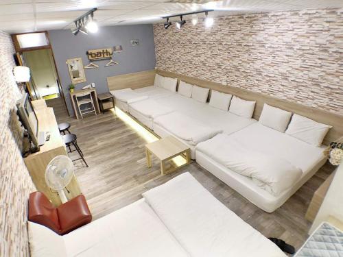a living room with white couches and a brick wall at 近 距離 in Taichung