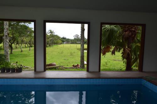 Zimmer mit Fenstern und Poolblick in der Unterkunft Recanto dos Bambus Eco in Torres