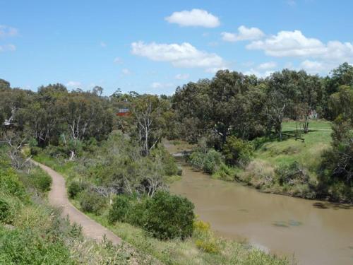 a river with a dirt road next to a forest at Werribee Blast from the Past in Werribee