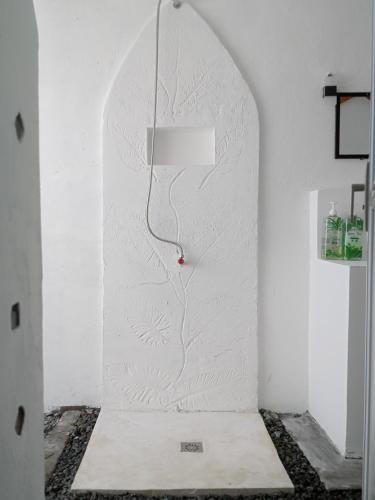 a room with a white wall with a lamp on it at Baywalk Suites Batangas in Laurel