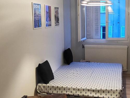 une chambre avec un lit dans une pièce avec une fenêtre dans l'établissement Studio du centre ville, à Limoges