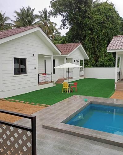 a backyard with a pool and a house at Zulanie's The Pool Cottage near D'Aur Beach, Melawi, Bachok in Bachok