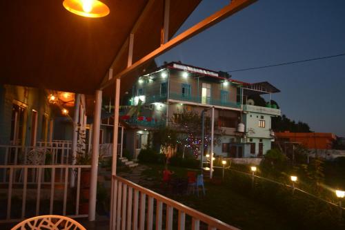 a house with lights on a balcony at night at Namaha hotel and cottages in Kanatal