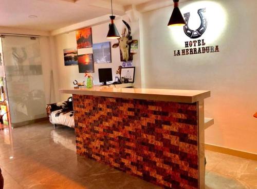 a bar in a room with a sign on the wall at Hotel La Herradura in Puerto López