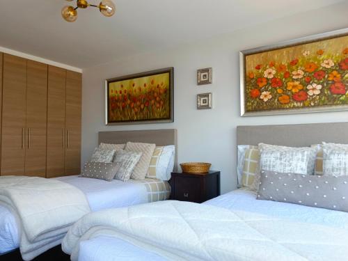 two beds in a bedroom with a painting on the wall at CENTRAL Apartment, 3Beds - Balcony - Parking - 6thFLOOR in Quito