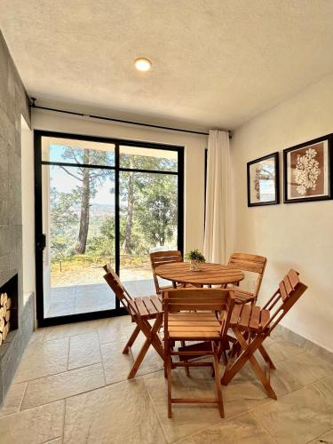 a dining room with a table and chairs and a large window at Casa Madera 1B in Zacatlán