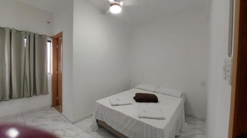 a white room with a bed with towels on it at Hotel Milagre Das Águas in Aparecida