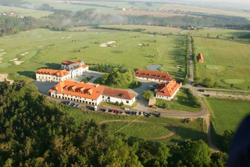 an aerial view of a mansion with a golf course at Darovanský Dvůr - Wellness & Golf Hotel in Břasy