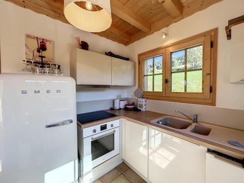 une cuisine avec un réfrigérateur blanc et un évier dans l'établissement Demi-chalet à deux pas des remontées mécaniques avec Wifi - FR-1-560-6, à Combloux