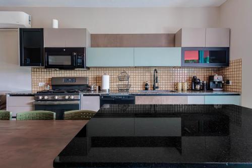 a kitchen with a black counter top and white cabinets at Villa Esmeralda - Private Pool - Sleeps 18 Guest in Piedra Gorda