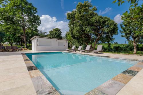 a swimming pool with chairs and a building at Villa Esmeralda - Private Pool - Sleeps 18 Guest in Piedra Gorda