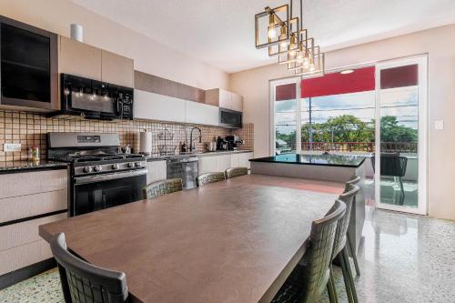 a large kitchen with a wooden table and chairs at Villa Esmeralda - Private Pool - Sleeps 18 Guest in Piedra Gorda