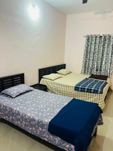 two beds sitting next to each other in a bedroom at Kadampil Bliss in Marayoor