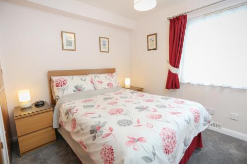 66D South Snowdon Wharf في بورثمادوج: غرفة نوم بسرير ونافذة ذات ستائر حمراء