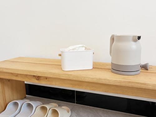 a coffee maker and shoes on a wooden shelf at Bed& in Mangshi