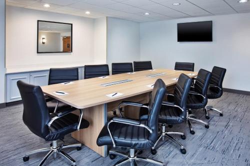 a conference room with a wooden table and black chairs at Staybridge Suites Omaha 80th and Dodge by IHG in Omaha