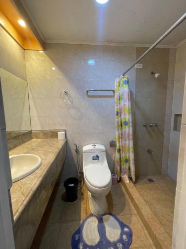 a bathroom with a toilet and a sink and a shower at Casa La Viva - house with pool in Tagaytay