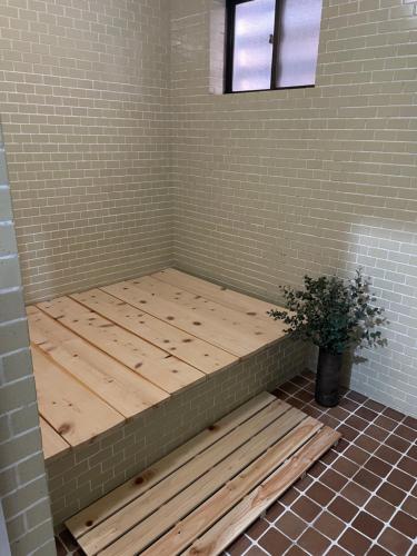 a wooden bench in a corner of a room at Silver Fox Madarao in Iiyama