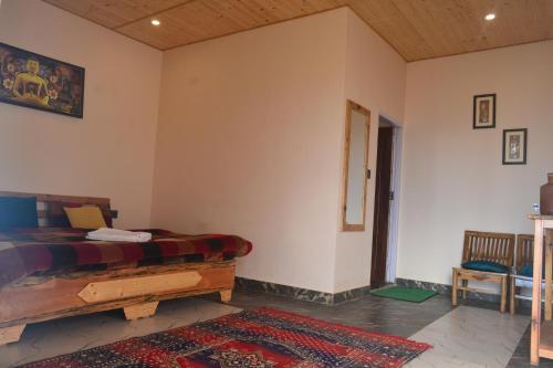 a bedroom with a bed in a room with a rug at Namaha hotel and cottages in Kanatal