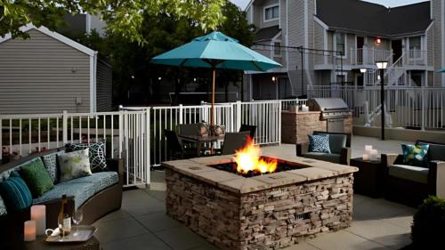 a patio with a fire pit and an umbrella at Sonesta ES Suites Cincinnati - Sharonville West in Sharonville