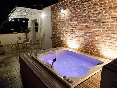 a hot tub in a room with a brick wall at Hermoso Penthouse con jacuzzi en terraza in Lima