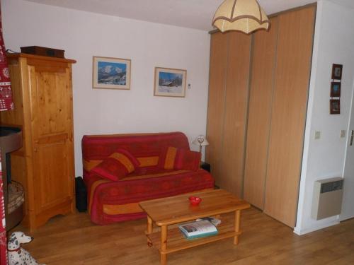 un salon avec un canapé rouge et une table dans l'établissement Studio Cabine Sud-Ouest avec Balcon et Parking à Barcelonnette - FR-1-804-9, à Barcelonnette