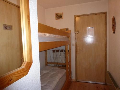 Cette petite chambre comprend des lits superposés et une porte. dans l'établissement Studio avec balcon à Barcelonnette, 4 couchages - FR-1-804-33, à Barcelonnette