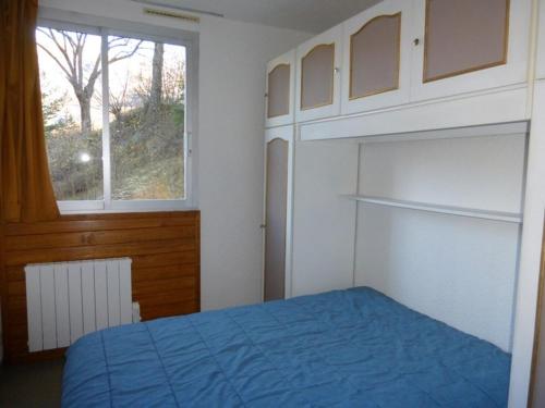 une chambre avec un lit bleu et une fenêtre dans l'établissement Appartement 3 pièces au Sauze, 7 couchages, station proche des pistes - FR-1-804-12, au Sauze