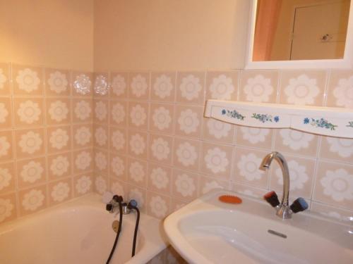 une salle de bain avec un lavabo, une baignoire et un miroir dans l'établissement Appartement 3 pièces au Sauze, 7 couchages, station proche des pistes - FR-1-804-12, au Sauze