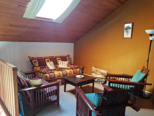 - un salon avec un lit, des chaises et une lucarne dans l'établissement Duplex 3 pièces avec balcon, proche Barcelonnette - FR-1-804-35, à Saint-Pons