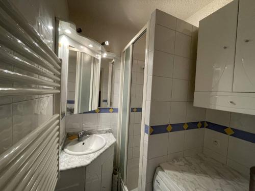 une salle de bain avec un lavabo et un miroir dans l'établissement Charmant T2 à Barcelonnette avec balcon et parking - FR-1-804-43, à Barcelonnette