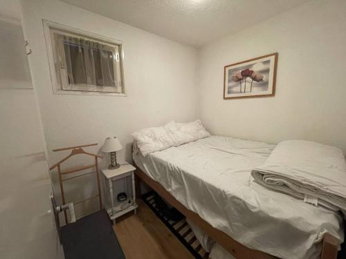 une petite chambre avec un lit et une fenêtre dans l'établissement Charmant T2 à Barcelonnette avec balcon et parking - FR-1-804-43, à Barcelonnette