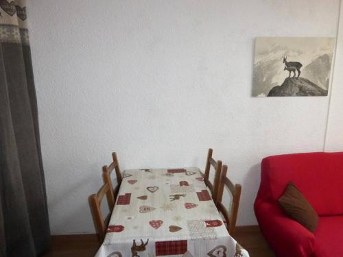 une salle à manger avec une table et une chaise rouge dans l'établissement Studio au centre de Sauze avec balcon - FR-1-804-44, au Sauze