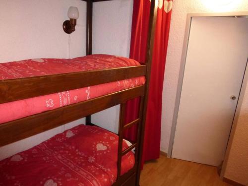 - une chambre avec 2 lits superposés et des rideaux rouges dans l'établissement Studio au centre de Sauze avec balcon - FR-1-804-44, au Sauze