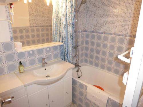 une salle de bain carrelée bleue avec un lavabo et une baignoire dans l'établissement Studio au centre de Sauze avec balcon - FR-1-804-44, au Sauze