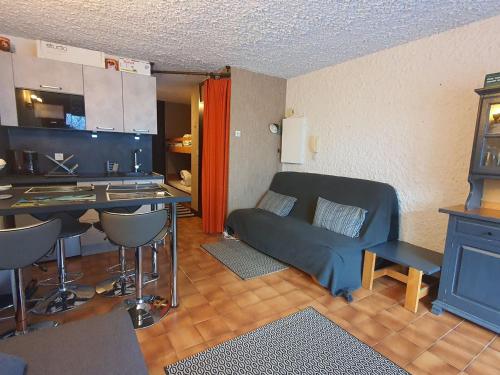 un petit salon avec un canapé et une cuisine dans l'établissement Studio spacieux près des pistes de ski avec balcon et parking - FR-1-692-111, à La Chapelle-dʼAbondance