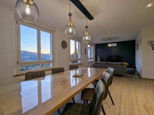 une salle à manger avec une grande table et des chaises en bois dans l'établissement Appartement spacieux à Le Tholy, 6 pers, Vosges - FR-1-589-784, à Le Tholy