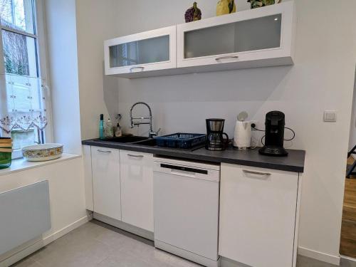 une cuisine avec des armoires blanches et un évier dans l'établissement Appartement romantique à Verdun avec parking privé - FR-1-585-168, à Verdun-sur-Meuse